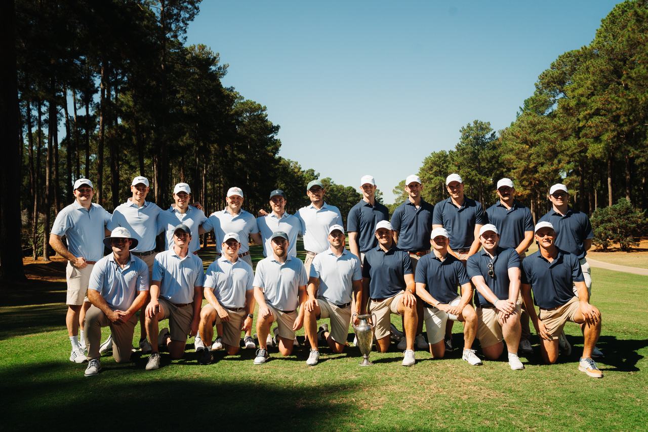 The full 2026 field together on the fairway at Pinewild Country Club, both teams around the trophy